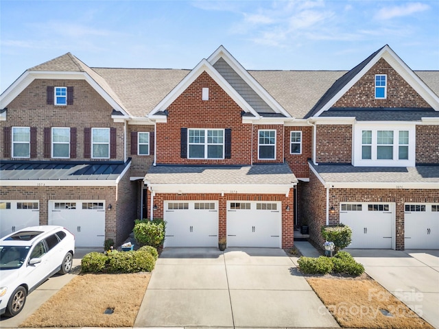 townhome / multi-family property featuring a garage, roof with shingles, concrete driveway, and brick siding