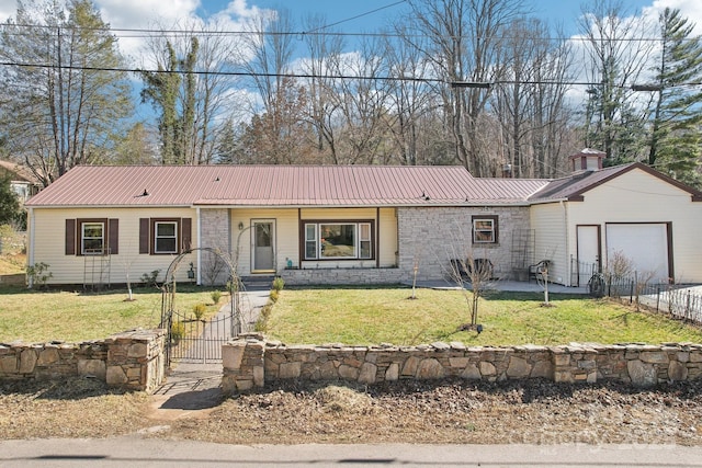 single story home with stone siding, metal roof, an attached garage, fence, and a front lawn