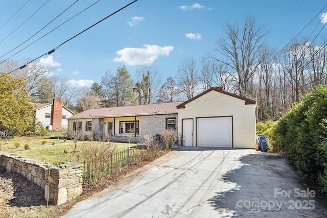 ranch-style home with metal roof, an attached garage, fence, driveway, and a front yard