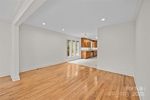 unfurnished living room with sink and light wood-type flooring