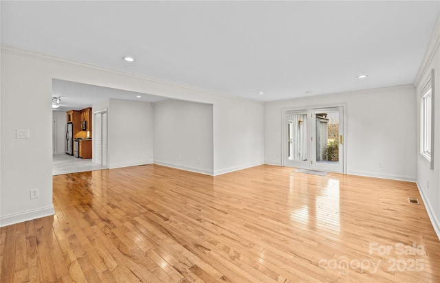 unfurnished living room with ornamental molding and light wood-type flooring