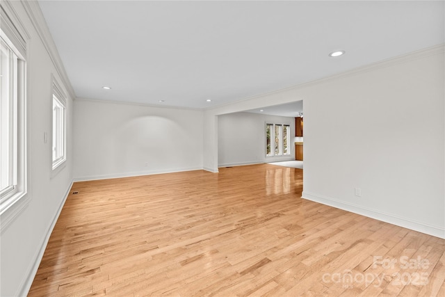 unfurnished room featuring ornamental molding and light wood-type flooring