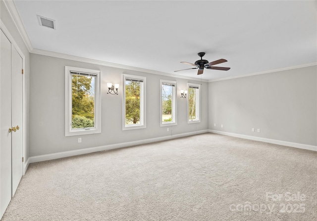 spare room featuring crown molding, ceiling fan, and light carpet