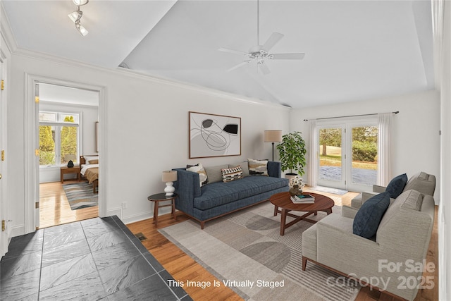 living room featuring ceiling fan, wood-type flooring, and vaulted ceiling