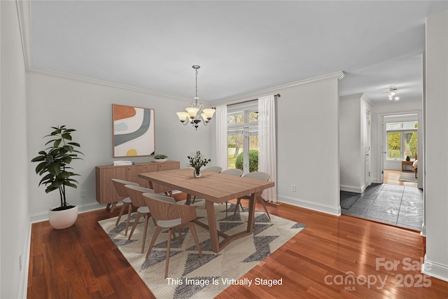 dining room featuring an inviting chandelier, hardwood / wood-style flooring, and ornamental molding