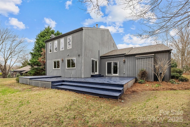 rear view of house featuring a wooden deck and a yard