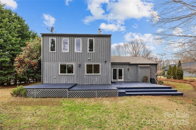 back of property featuring a wooden deck and a yard