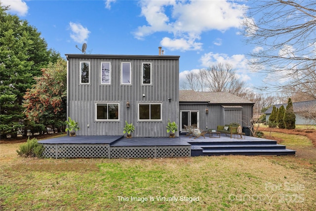 back of house with a wooden deck and a lawn