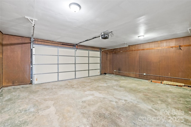 garage featuring a garage door opener and wood walls