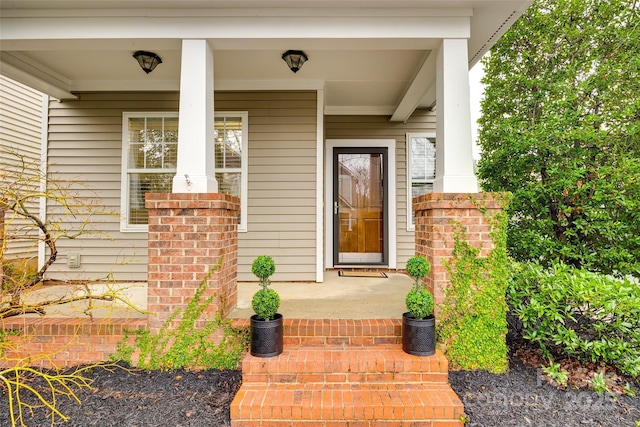 view of exterior entry featuring covered porch