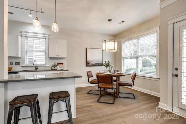 kitchen with hanging light fixtures, decorative backsplash, and white cabinets