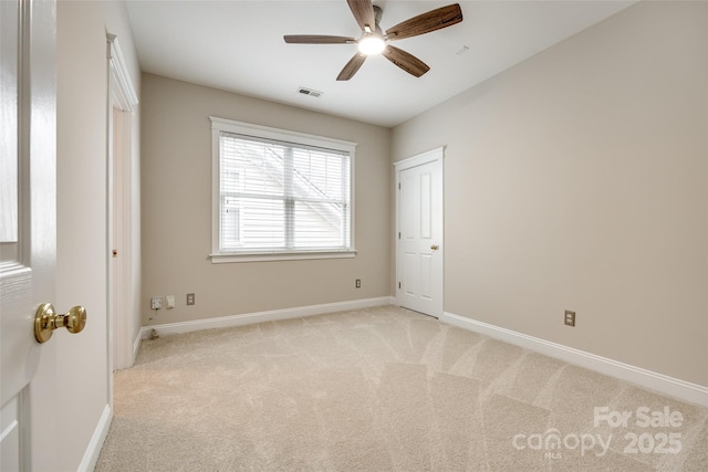 carpeted spare room with ceiling fan