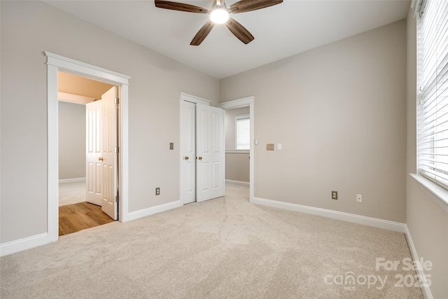 unfurnished bedroom featuring ceiling fan and light carpet