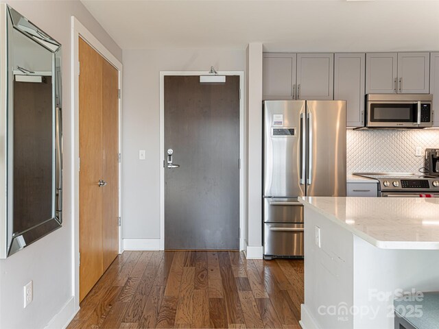 45 Asheland Ave Unit 302, Asheville, NC 28801 - kitchen featuring dark hardwood / wood-style flooring, backsplash, gray cabinets, and stainless steel appliances