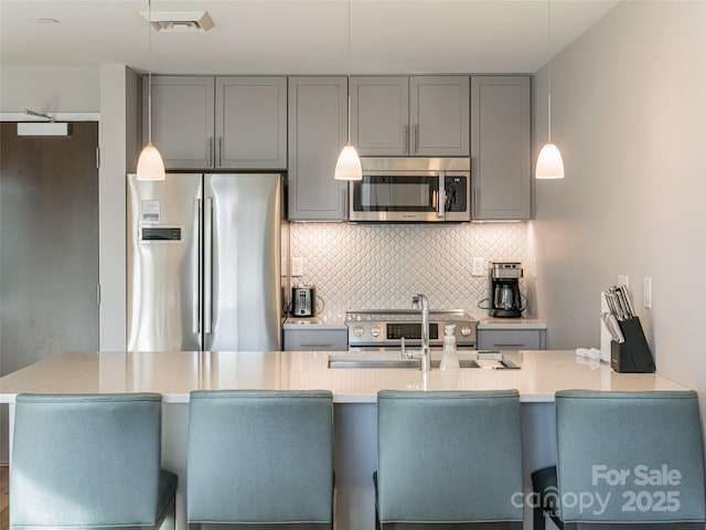 45 Asheland Ave Unit 302, Asheville, NC 28801 - kitchen featuring pendant lighting, sink, gray cabinets, stainless steel appliances, and decorative backsplash