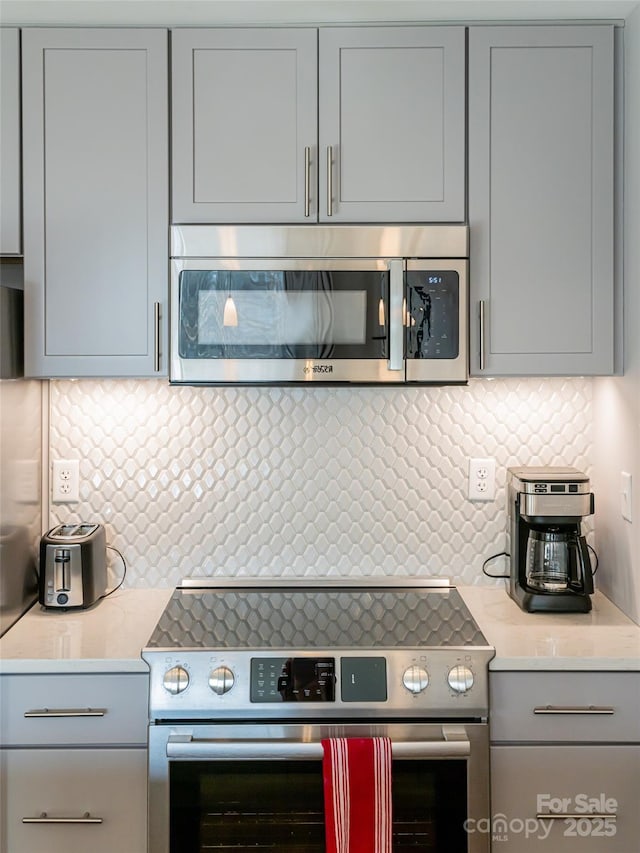 45 Asheland Ave Unit 302, Asheville, NC 28801 - kitchen with tasteful backsplash, gray cabinets, and appliances with stainless steel finishes