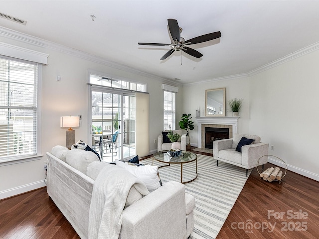 living room featuring dark hardwood / wood-style flooring, crown molding, and a healthy amount of sunlight