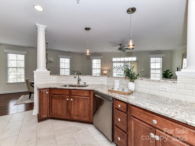 kitchen featuring dishwasher, pendant lighting, ornamental molding, sink, and ornate columns