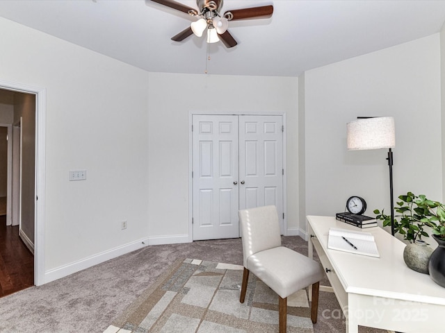 carpeted office space with ceiling fan