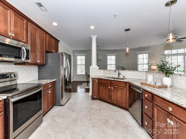 8925 Rosalyn Glen Rd, Cornelius, NC 28031 - kitchen with stainless steel appliances, tasteful backsplash, recessed lighting, ceiling fan, and decorative columns