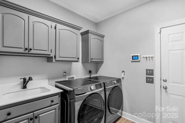 washroom with independent washer and dryer, cabinets, light hardwood / wood-style floors, and sink