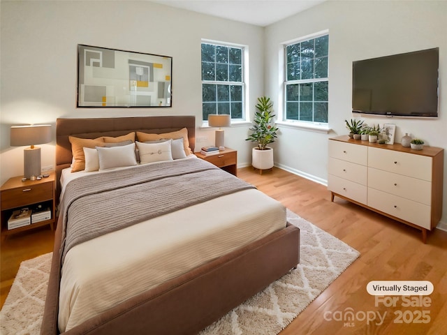 bedroom with light wood-type flooring and baseboards