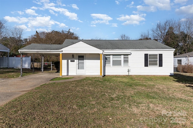 single story home featuring fence, a front lawn, roof with shingles, concrete driveway, and a carport