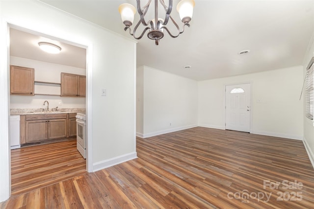 unfurnished dining area featuring baseboards, dark wood-style floors, and a sink