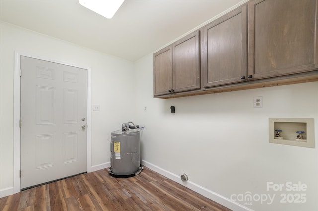 laundry area featuring dark wood finished floors, cabinet space, electric water heater, washer hookup, and baseboards