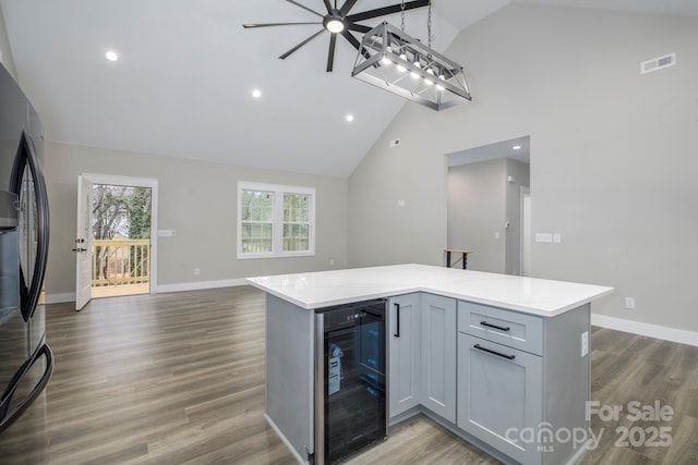 kitchen featuring gray cabinetry, fridge, dark hardwood / wood-style flooring, decorative light fixtures, and beverage cooler