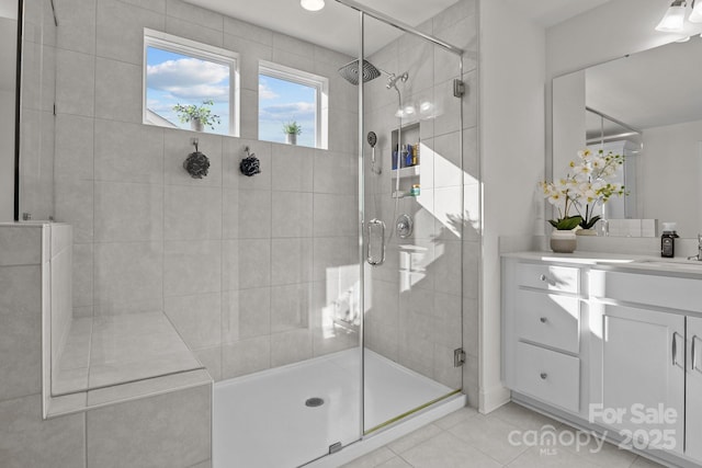 full bathroom with tile patterned floors, a stall shower, and vanity