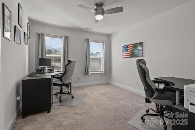 home office with visible vents, baseboards, a ceiling fan, and light colored carpet