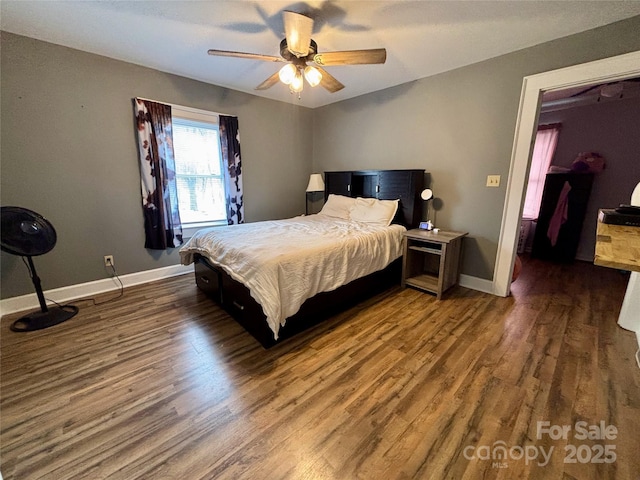 bedroom with dark wood-style floors, ceiling fan, and baseboards