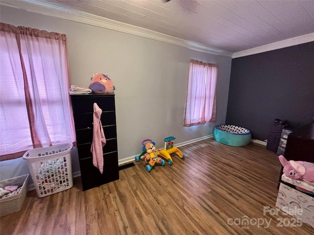 bedroom with ornamental molding, wood finished floors, and baseboards