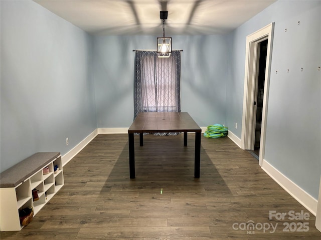 unfurnished office with baseboards and dark wood-style flooring