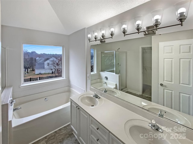 bathroom with a textured ceiling, a sink, vaulted ceiling, a bath, and a stall shower