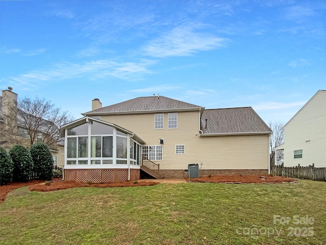 back of property with central AC unit, fence, a sunroom, a lawn, and a chimney