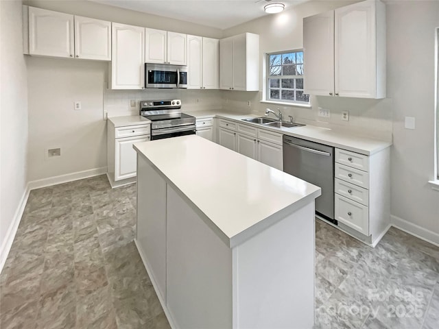 kitchen with stainless steel appliances, a sink, and white cabinets