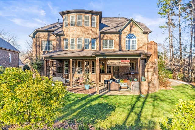 back of property featuring a yard, outdoor lounge area, and a patio area