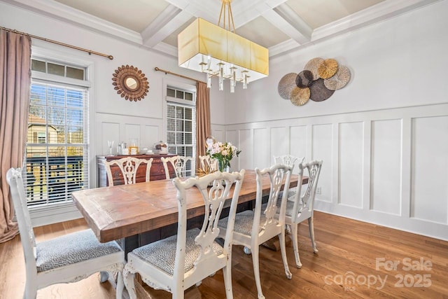 dining area featuring coffered ceiling, hardwood / wood-style flooring, and beam ceiling