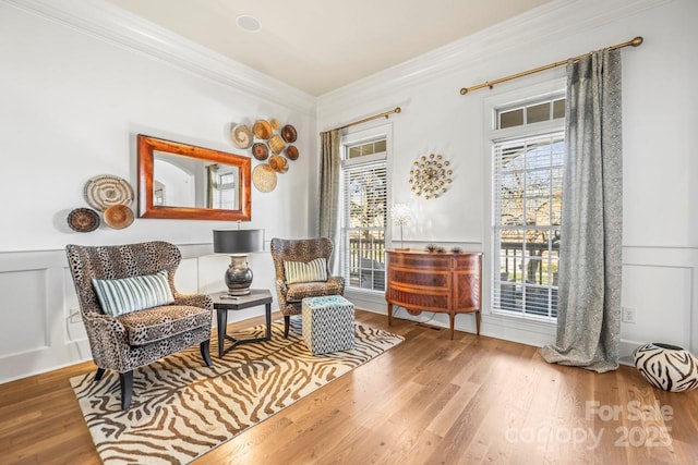 sitting room with hardwood / wood-style flooring, ornamental molding, and a wealth of natural light