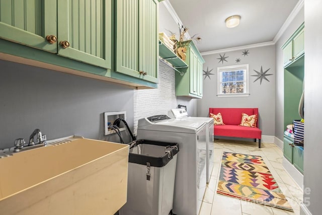 clothes washing area featuring sink, separate washer and dryer, crown molding, and cabinets