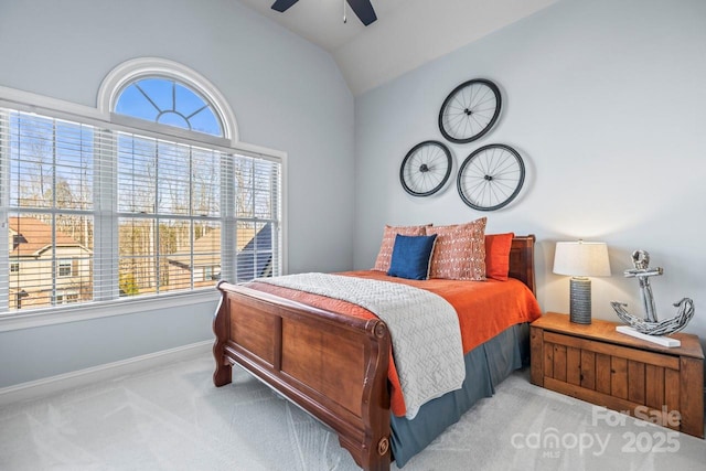 bedroom with multiple windows, lofted ceiling, ceiling fan, and light colored carpet