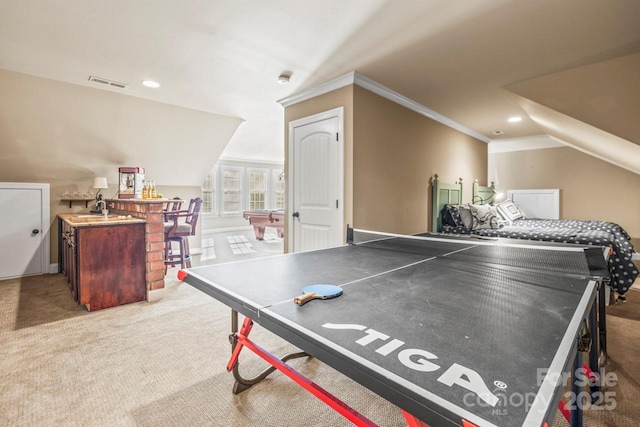 game room featuring wet bar, lofted ceiling, carpet flooring, and ornamental molding