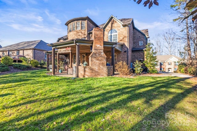 rear view of property with a yard and a patio area