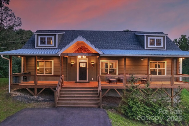 rustic home with covered porch, metal roof, and roof with shingles