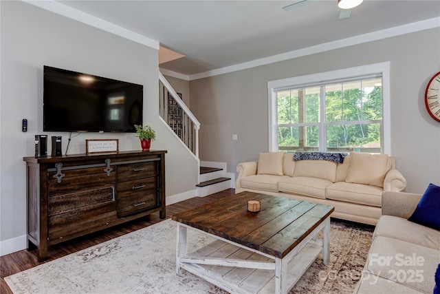 living area with ornamental molding, stairway, baseboards, and wood finished floors