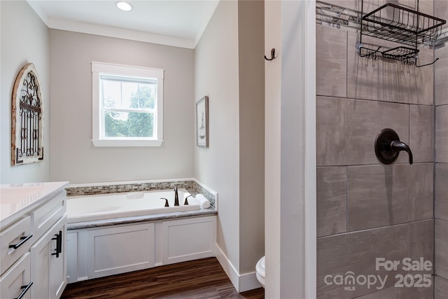 bathroom with tiled shower, a garden tub, vanity, and wood finished floors