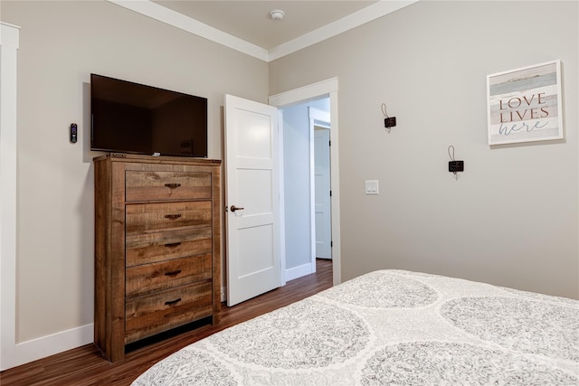 bedroom featuring ornamental molding, dark wood finished floors, and baseboards