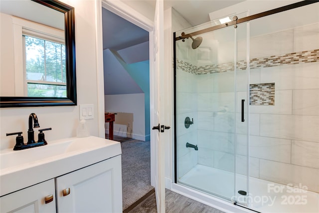 full bathroom featuring a stall shower, vaulted ceiling, and vanity